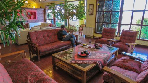 a man sitting on a couch in a living room at Lar Aike in El Calafate