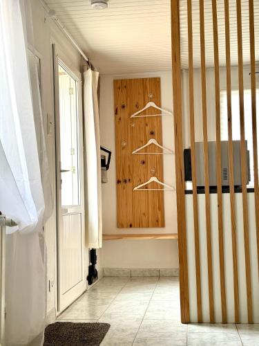 a room with a wooden wall with hangers at T2 Cosy in Mende