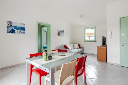 a living room with a white table and red chairs at Sunset Apartment 2Bedr Sunset View Parking in Bosa
