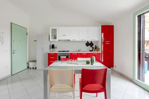 a kitchen with red cabinets and red chairs at Sunset Apartment 2Bedr Sunset View Parking in Bosa