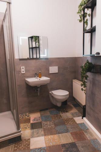 a bathroom with a sink and a toilet and a mirror at Cityloft Erfurt in Erfurt