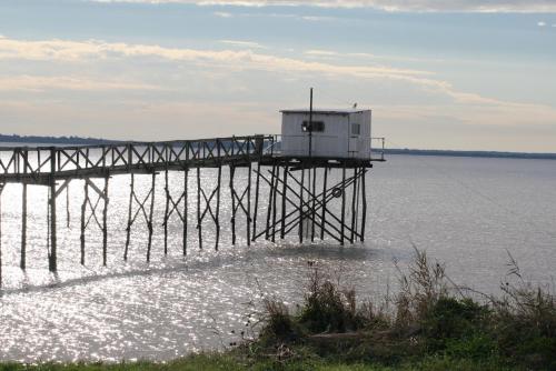 a building on a pier in the water at Gîte Rouge Calme et Nature in Allas-Bocage