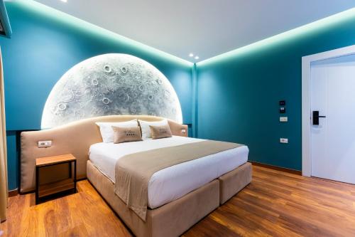 a bedroom with a large bed in a blue room at Bliss Boutique Hotel in Durrës