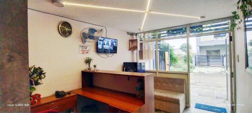 a living room with a tv on a wall at Hotel Sutlaj in Indore