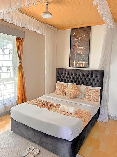a bedroom with a large bed with shoes on it at Luxury 4 BR Homely Apt with a pool in Kisumu