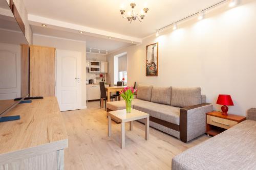 a living room with a couch and a table at POKOJE APARTAMENTY ANASTAZJA in Grzybowo