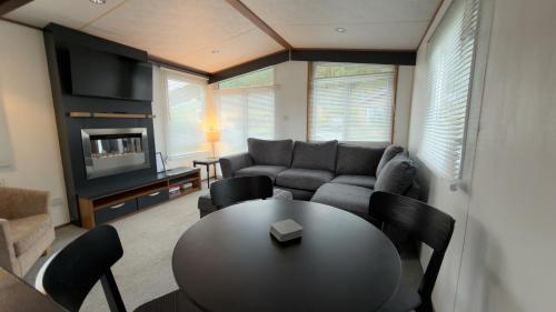 a living room with a table and a couch at Woodside, Meadows Retreat, Cockermouth in Plumbland