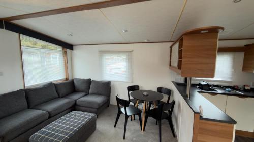 a small living room with a couch and a table at Woodside, Meadows Retreat, Cockermouth in Plumbland
