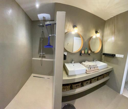 a bathroom with two sinks and two mirrors at Maison familiale in Bidart