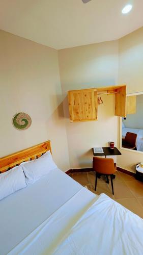 a bedroom with a white bed and a table at Esther & Hans Homes in Dodoma
