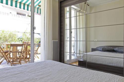 a bedroom with a bed and a balcony with a table at MY CASA AUNE - Free Parking & Terrace in Nice