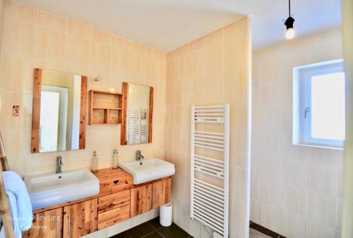 a bathroom with two sinks and a mirror at La Luberonne gordes in Gordes