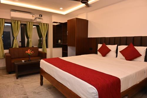 a bedroom with a large bed with red pillows at VMR Hotel Port Blair in Jangli Ghāt