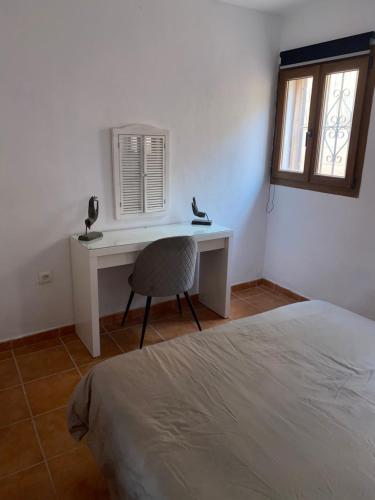 a bedroom with a desk and a bed and a window at Casa Amigos Rural in Cuevas del Almanzora