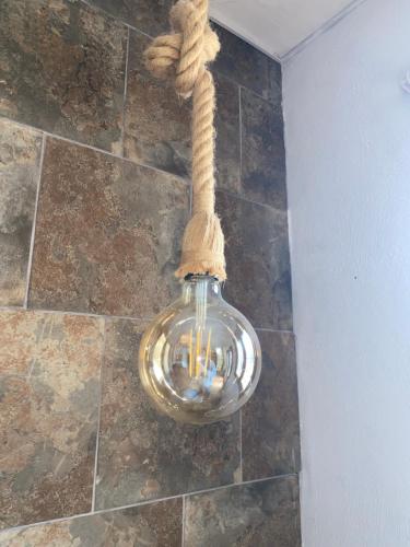 a light bulb with a rope hanging from a wall at Casa Amigos Rural in Cuevas del Almanzora