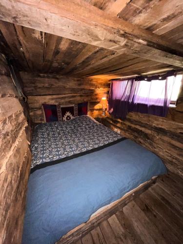 a bedroom with a bed in a log cabin at La Cabane Aux Loups in Crépy-en-Valois