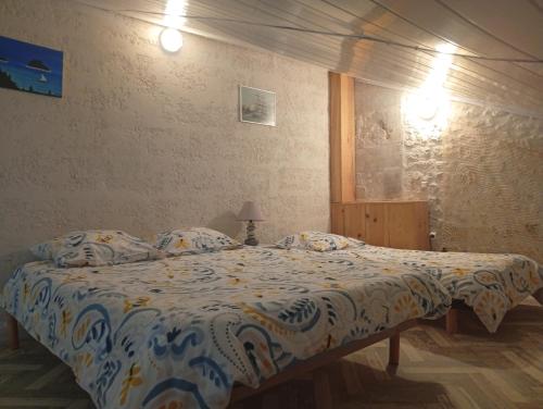 a bedroom with a bed with a comforter at Domaine la belle charentaise in Chadenac