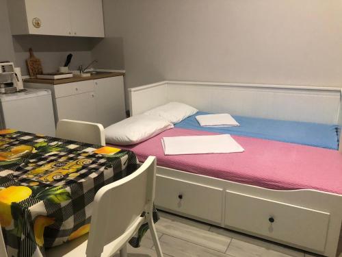 a room with a bed and a table and a kitchen at Sicily Sud-Est in Avola