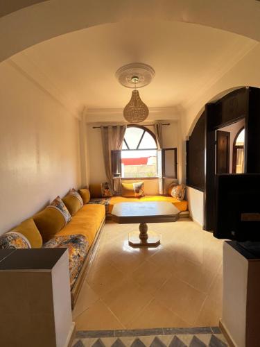 a living room with a couch and a table at Tamraght Sunny apartment in Tamraght Ouzdar