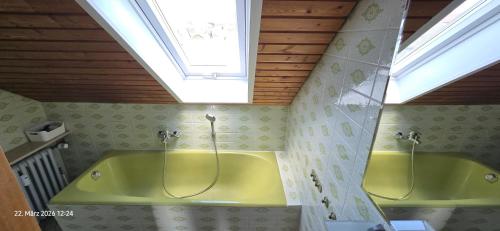 a bathroom with a green tub and a skylight at Ferienwohnung mit Kreuzbergblick in Bischofsheim an der Rhön