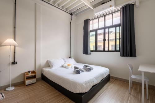 a bedroom with a bed and a window and a desk at Cool cozy In Yaowarat in Bangkok