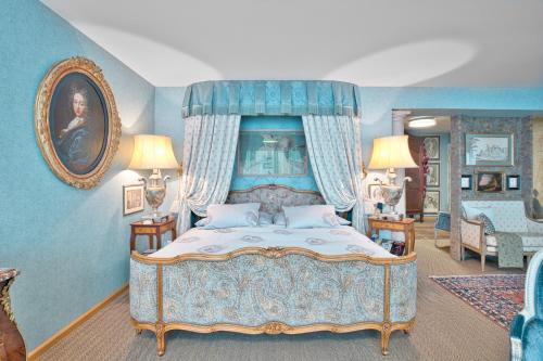 a bedroom with a bed with a blue canopy at Historic Cinema Suite with Private Art Collection - Basel in Basel