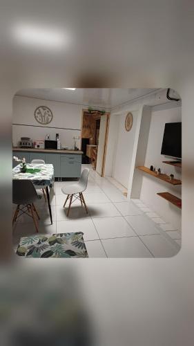a living room with a table and a kitchen at Ti case ali in Saint-Benoît