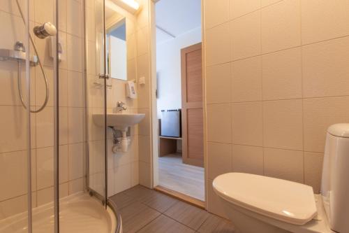a bathroom with a toilet and a sink and a shower at Carolina Hotel in Pärnu