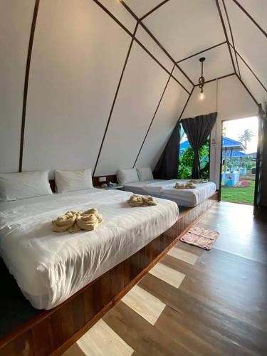 two beds in a tent with towels on them at Hosanna village in Semporna