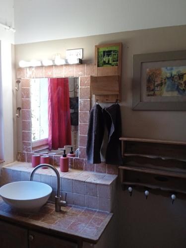 a bathroom with a sink and a brick wall at Le Jardin d'Anna in Saint-Eutrope-de-Born