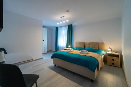 a bedroom with a blue bed and a chair at Vila Petro in Iaşi