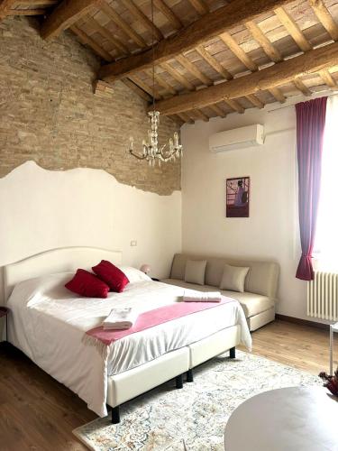 a bedroom with a large bed and a couch at Residenza Toscanini in Ravenna