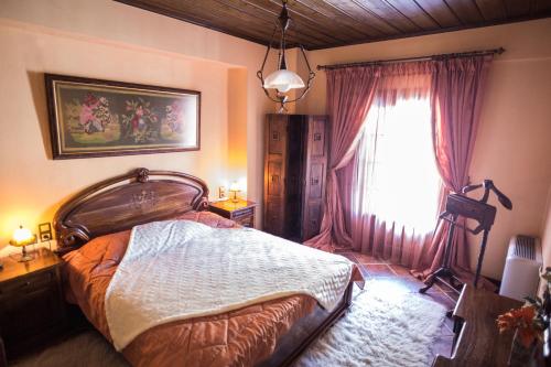 a bedroom with a large bed and a window at Archontiko Velousi in Pantévgeni