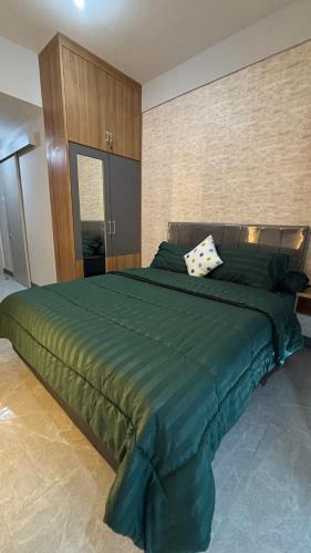 a bedroom with a large green bed in it at Sorici Studio at Bella Tower in Surabaya