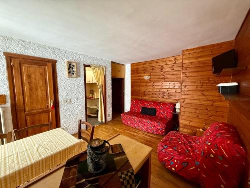 ein Wohnzimmer mit einem roten Sofa und einem Tisch in der Unterkunft Piccolo Bric in Ghigo