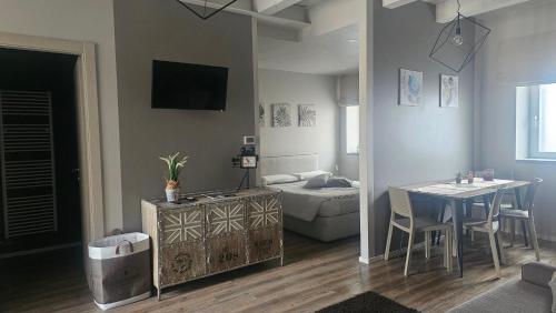 a living room with a table and a bed at appartamenti Il Borgo orchidea in Busca