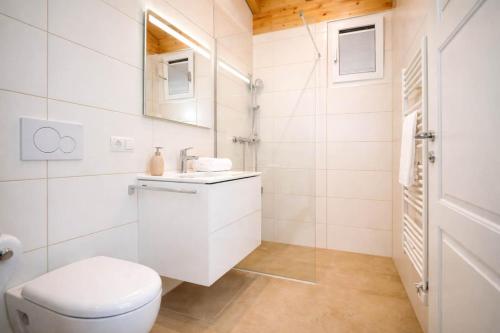 a white bathroom with a toilet and a sink at Tyrolschalet LITTLE LUCK - Private Pool & Mountain View in Rofansiedlung
