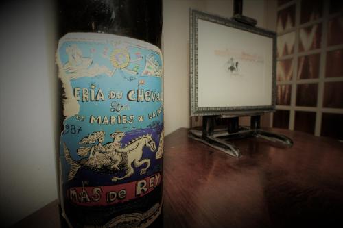 a bottle of wine sitting on a table next to a mirror at Logis Le Nid du Pont de Gau in Saintes-Maries-de-la-Mer