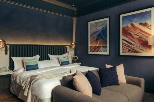 a bedroom with a large bed and a couch at Lyla Rooms in Edinburgh