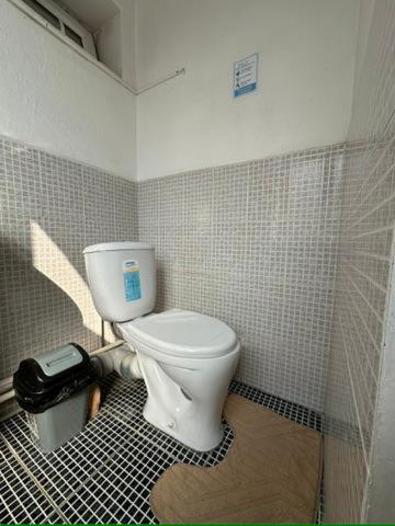 a bathroom with a toilet in a tiled room at Sunny Hostel in Osh
