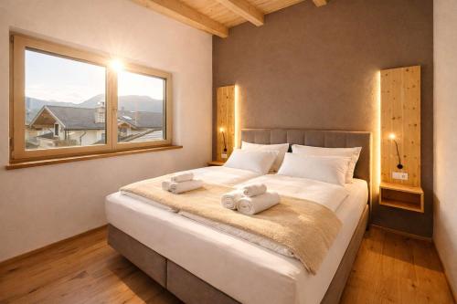 a bedroom with a large bed with two towels on it at ViVaZILARE - Design Loft with Terrace in Fügen