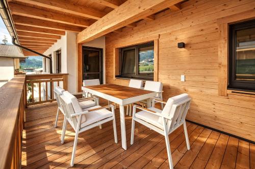a dining room with a table and chairs on a deck at ViVaZILARE - Design Loft with Terrace in Fügen
