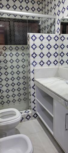 a bathroom with a white toilet and a sink at Recanto dos Passaros centro Penedo RJ in Penedo