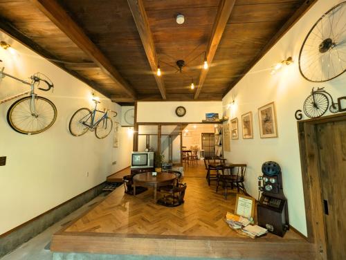 a room with a table and a bike hanging on the wall at Bike,Cafe and Inn 寄り道 in Iwagi-shima
