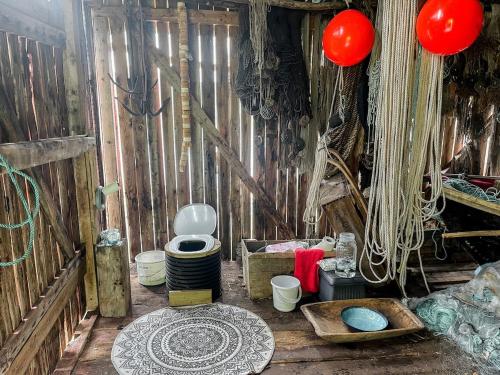 a room with a toilet and a table and red balloons at Unique boathouse with a spectacular view in Oldra