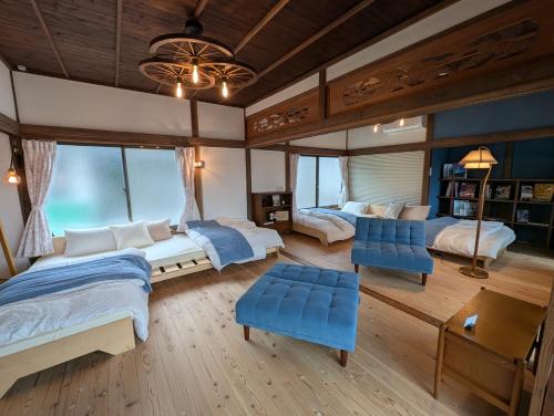 a bedroom with two beds and blue chairs at Bike,Cafe and Inn 寄り道 in Iwagi-shima