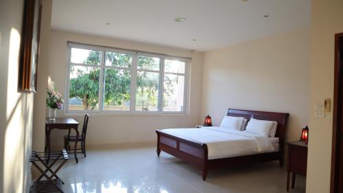 a bedroom with a bed and a large window at Three Kings Private Luxury Villa in Chiang Mai