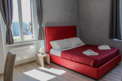 a red bed in a small room with a window at SunnyCornerinRHome in Rome
