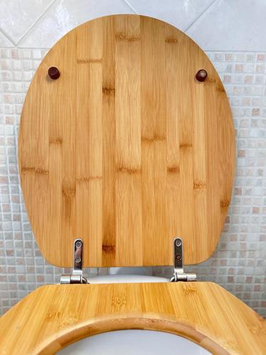 a wooden toilet seat lid in a bathroom at ALT alloggio turistico in Focene