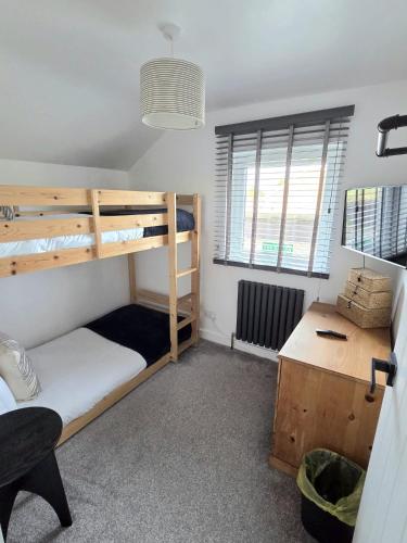 a dorm room with bunk beds and a desk at 12 Ivy Cottage in St Ives